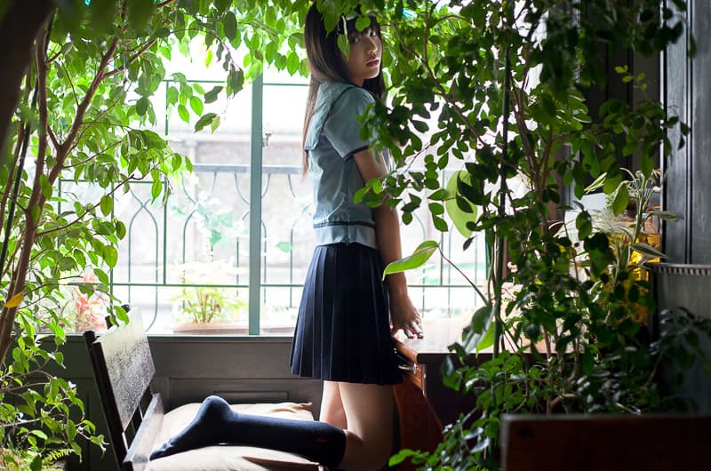 Side view of bare feet with stockings rolled down around ankles on a rumpled linen surface